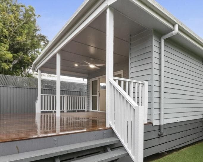 Covered wraparound deck DADU Bothell — timber decking ceiling fan recessed lighting white railing