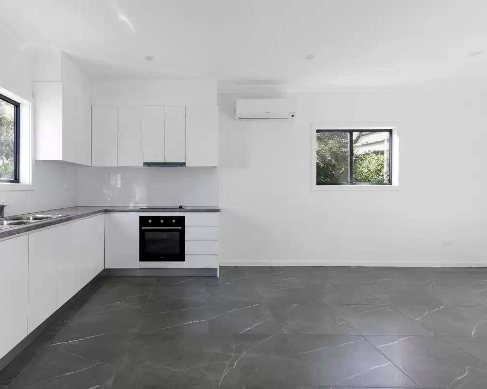 Modern DADU kitchen Edmonds — white gloss handleless cabinets marble porcelain floor mini-split