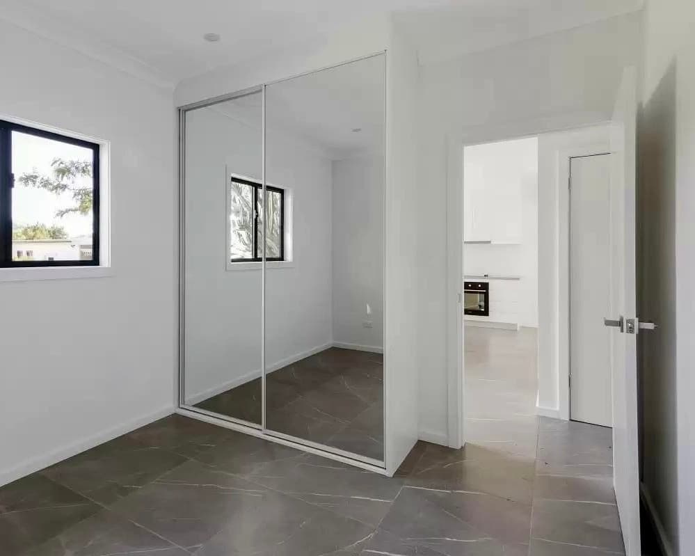 Modern DADU bedroom Edmonds — mirrored sliding closet doors marble-look porcelain floor