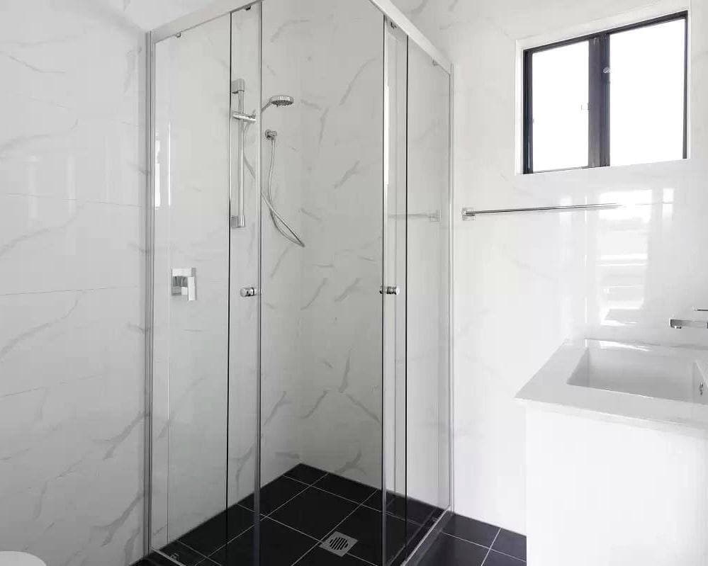 Modern DADU bathroom Edmonds — frameless glass shower marble tile wall-mounted vanity