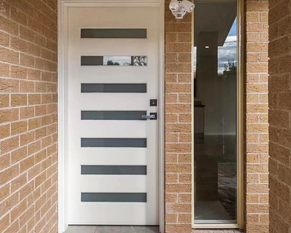 Attached ADU private entrance Kirkland — modern door glass sidelite brick exterior security light