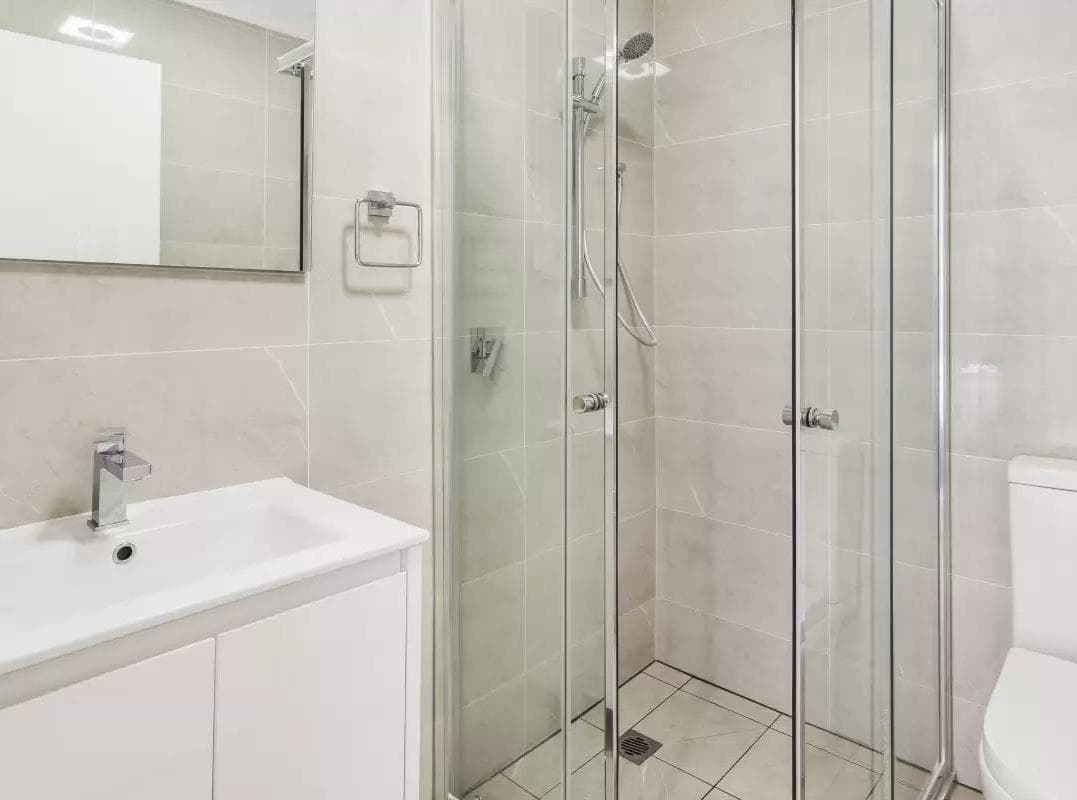 Premium ADU bathroom Kirkland — frameless glass shower floating vanity porcelain tile