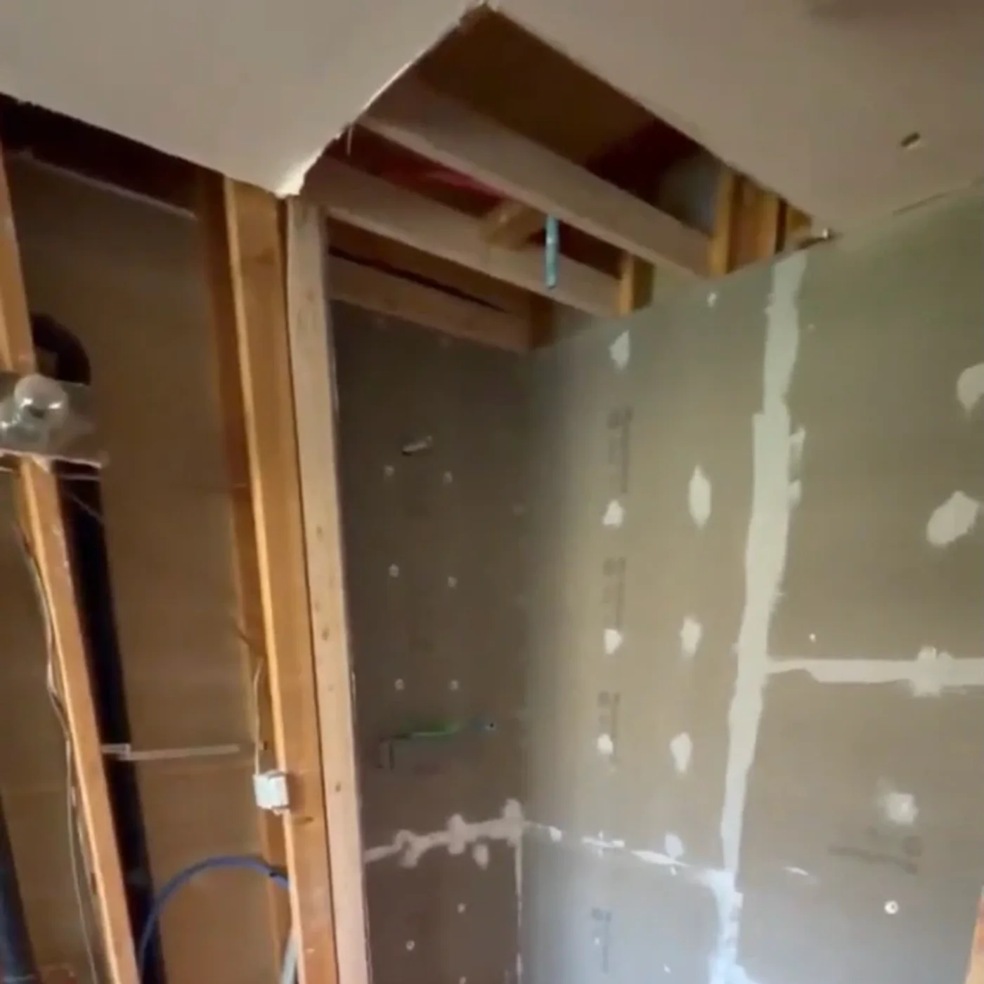 Kirkland master bathroom mid-build — open studs, cement board shower and heated-floor mat
