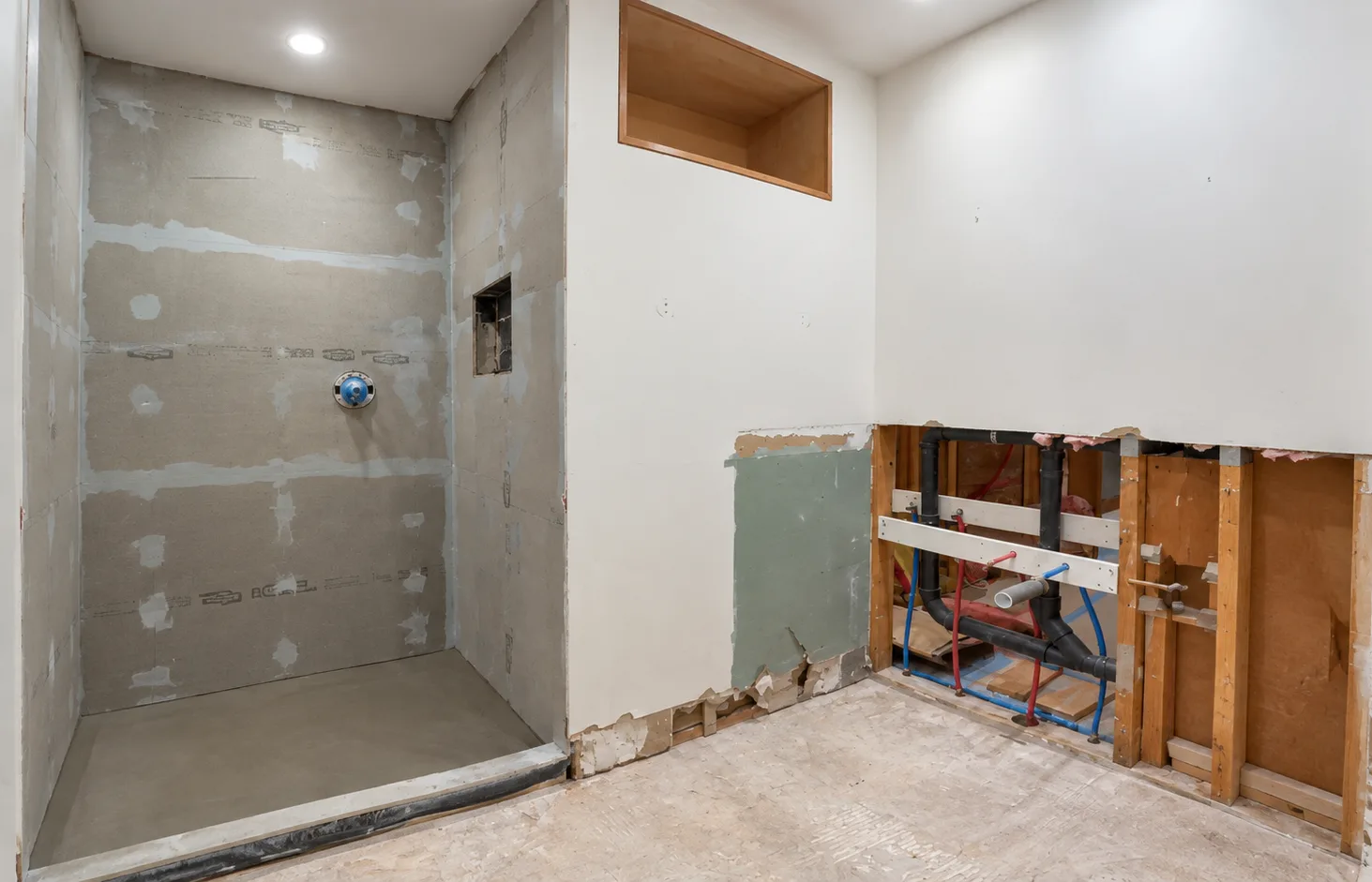 Redmond main bathroom during demolition — cement board and open plumbing