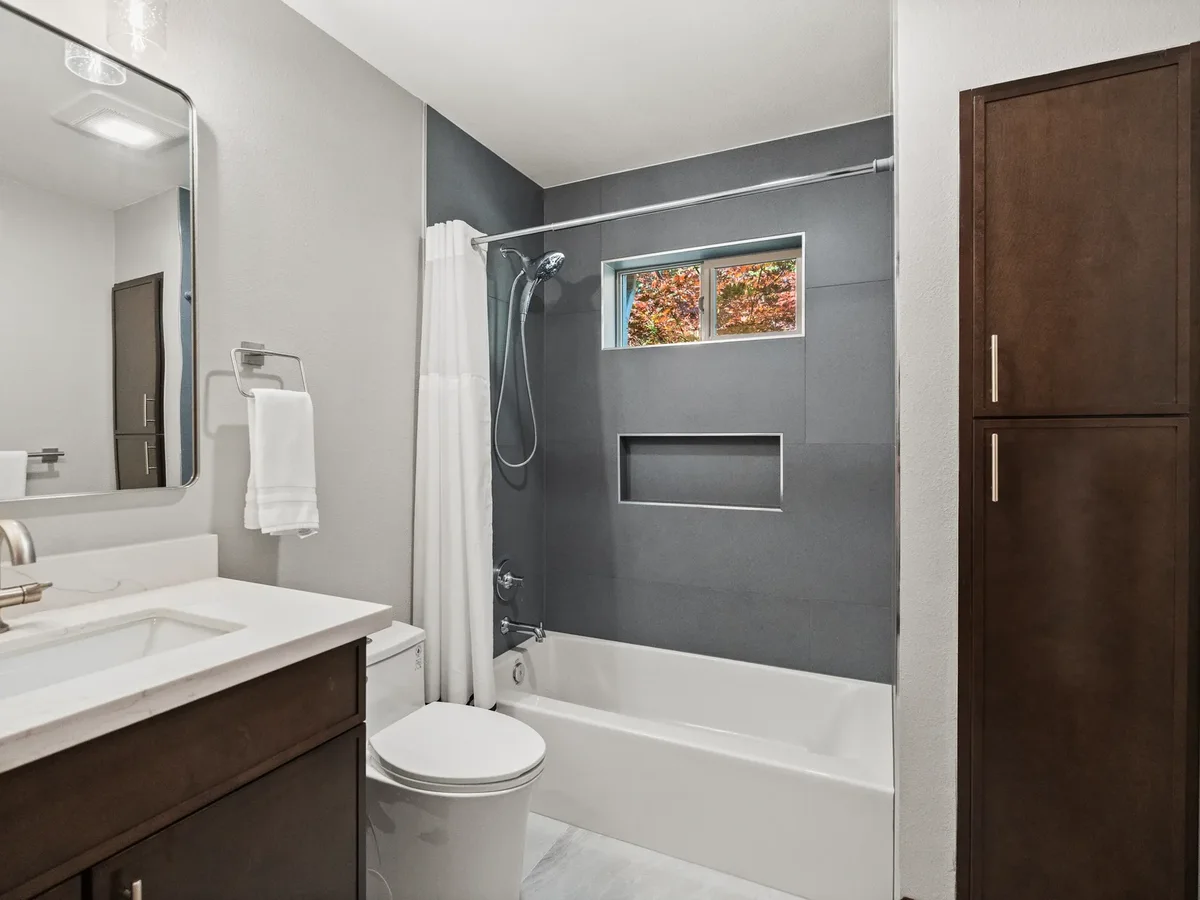 Second full bathroom with dark vanity, tub-shower and linen tower, Puyallup WA