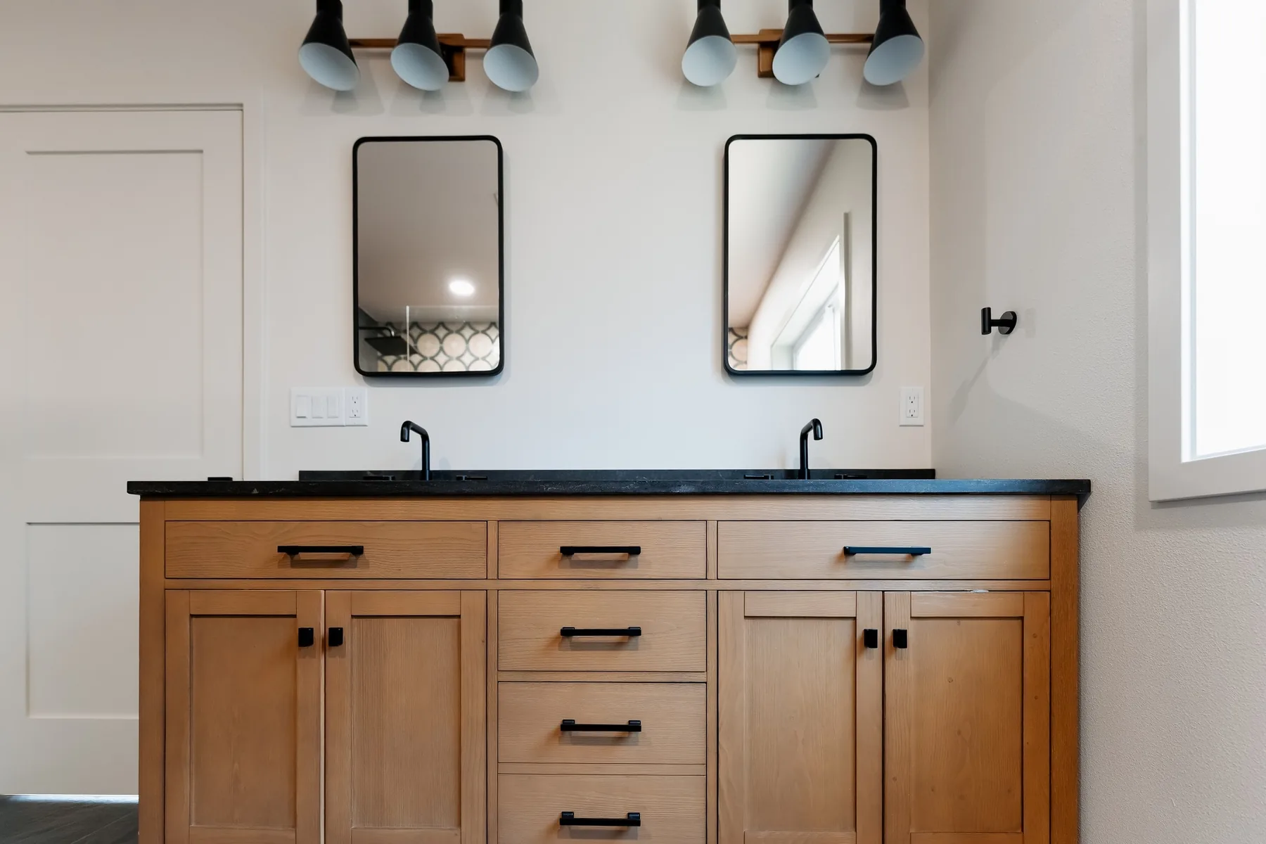 Oak double vanity with black quartz top, two black-framed mirrors and black sconces, Capitol Hill Seattle