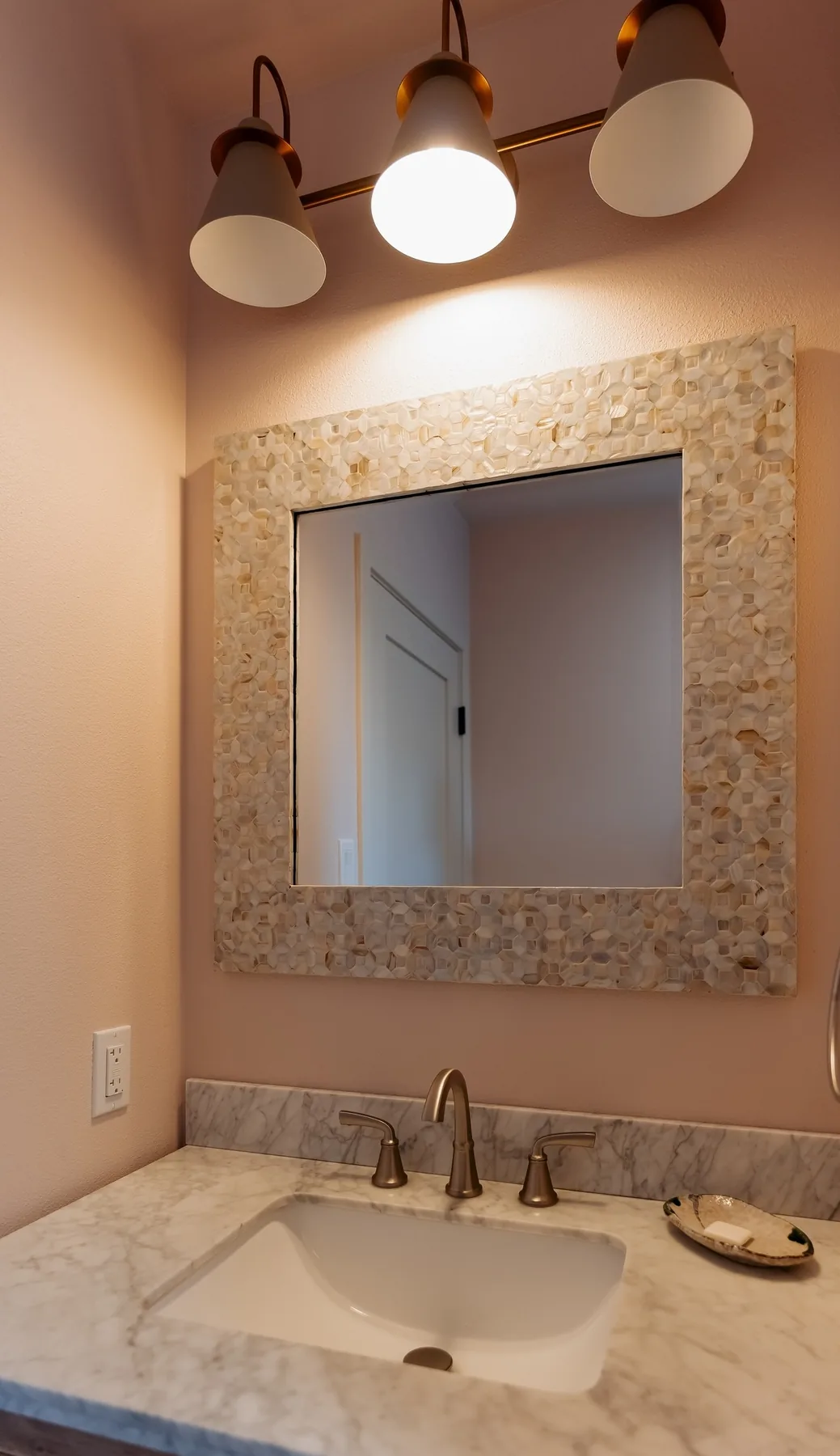 Marble-topped vanity with shell-framed mirror and bronze sconces, Capitol Hill bathroom