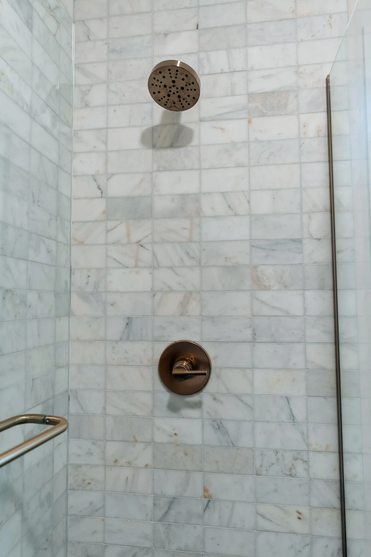 Shower with marble subway tile, brass fixtures and a glass panel, Capitol Hill