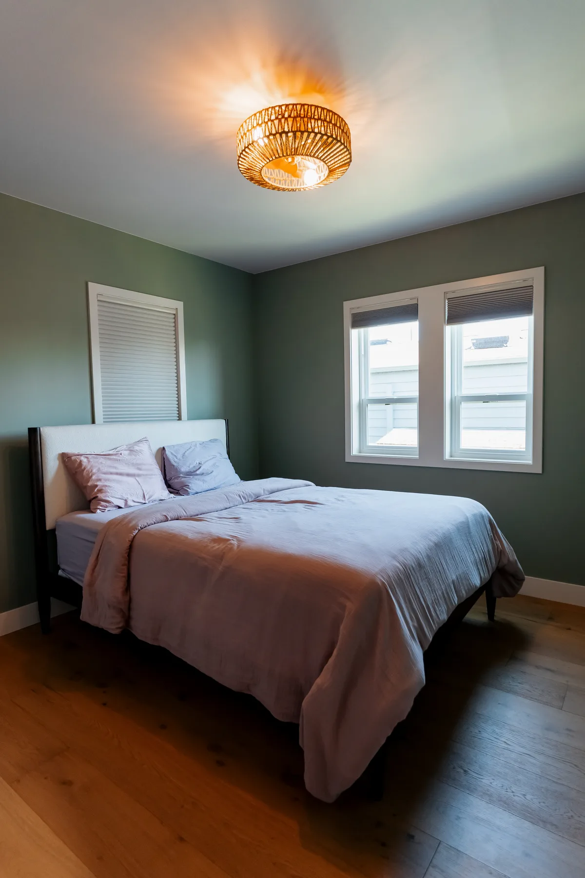 Bedroom with green walls, new window trim and oak floor