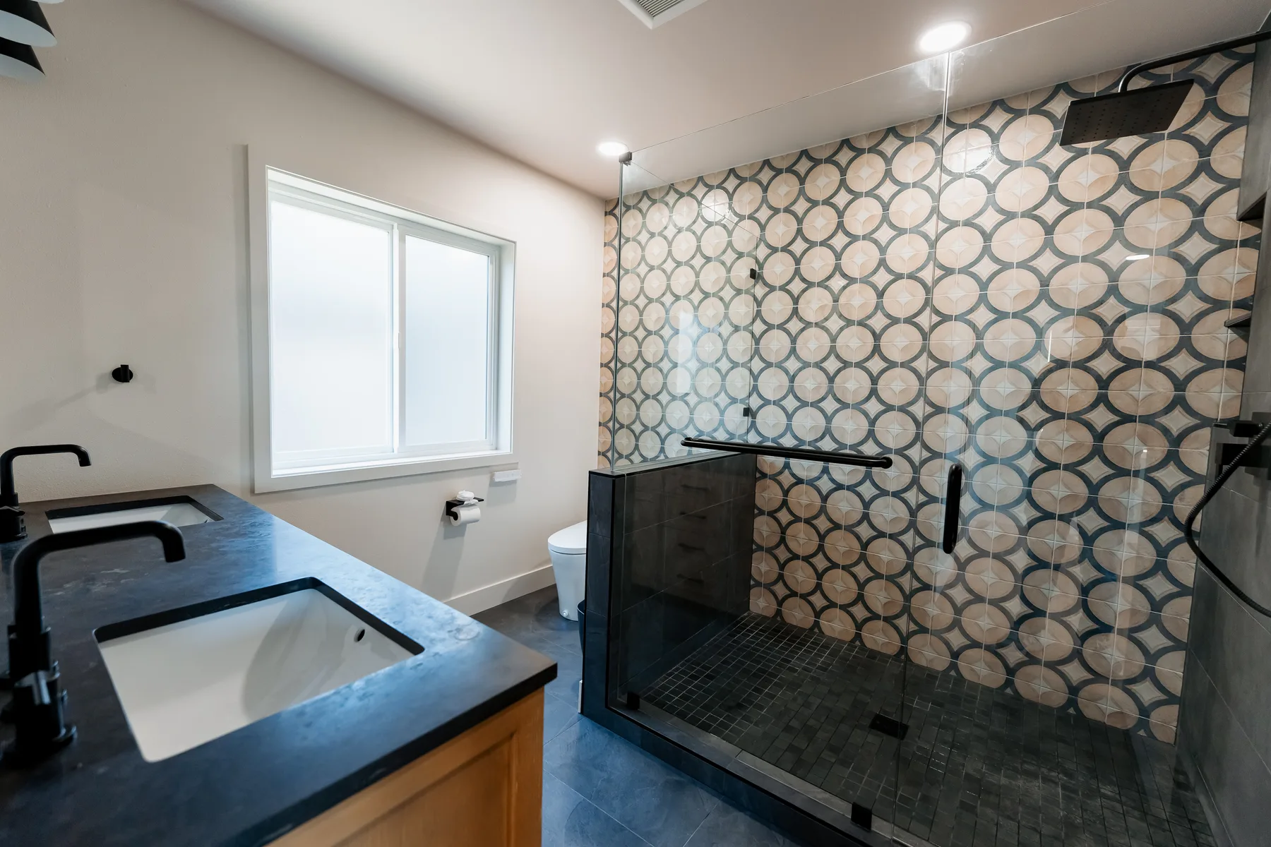 Main bathroom of the finished Capitol Hill remodel — oak vanity, black quartz and the patterned walk-in shower