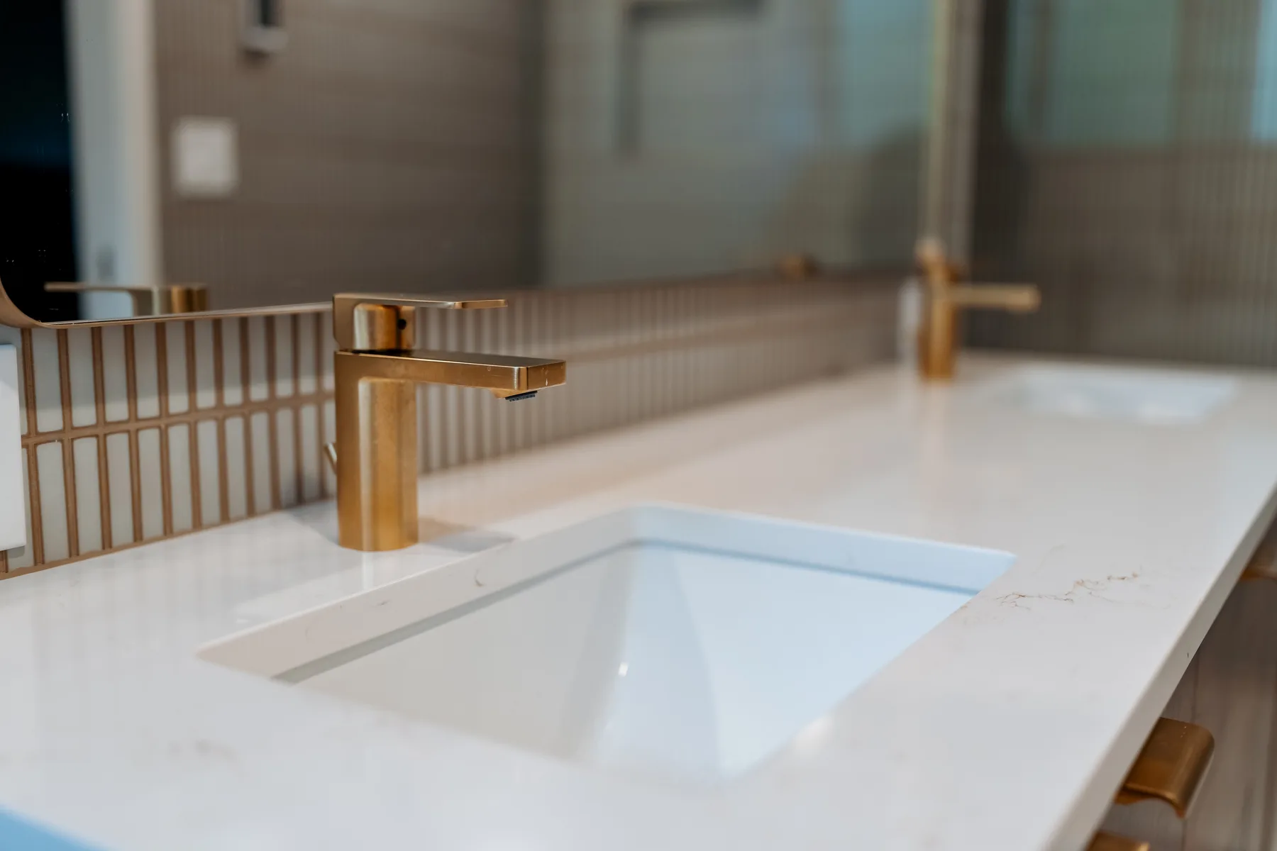 Brushed-brass faucet and undermount sink on white quartz