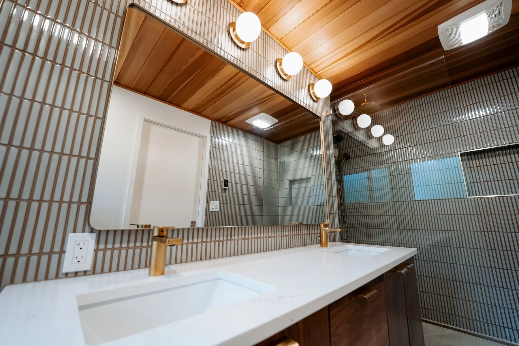 Walnut floating double vanity with white quartz top, wall-wide mirror and globe vanity lights, Kirkland master bath