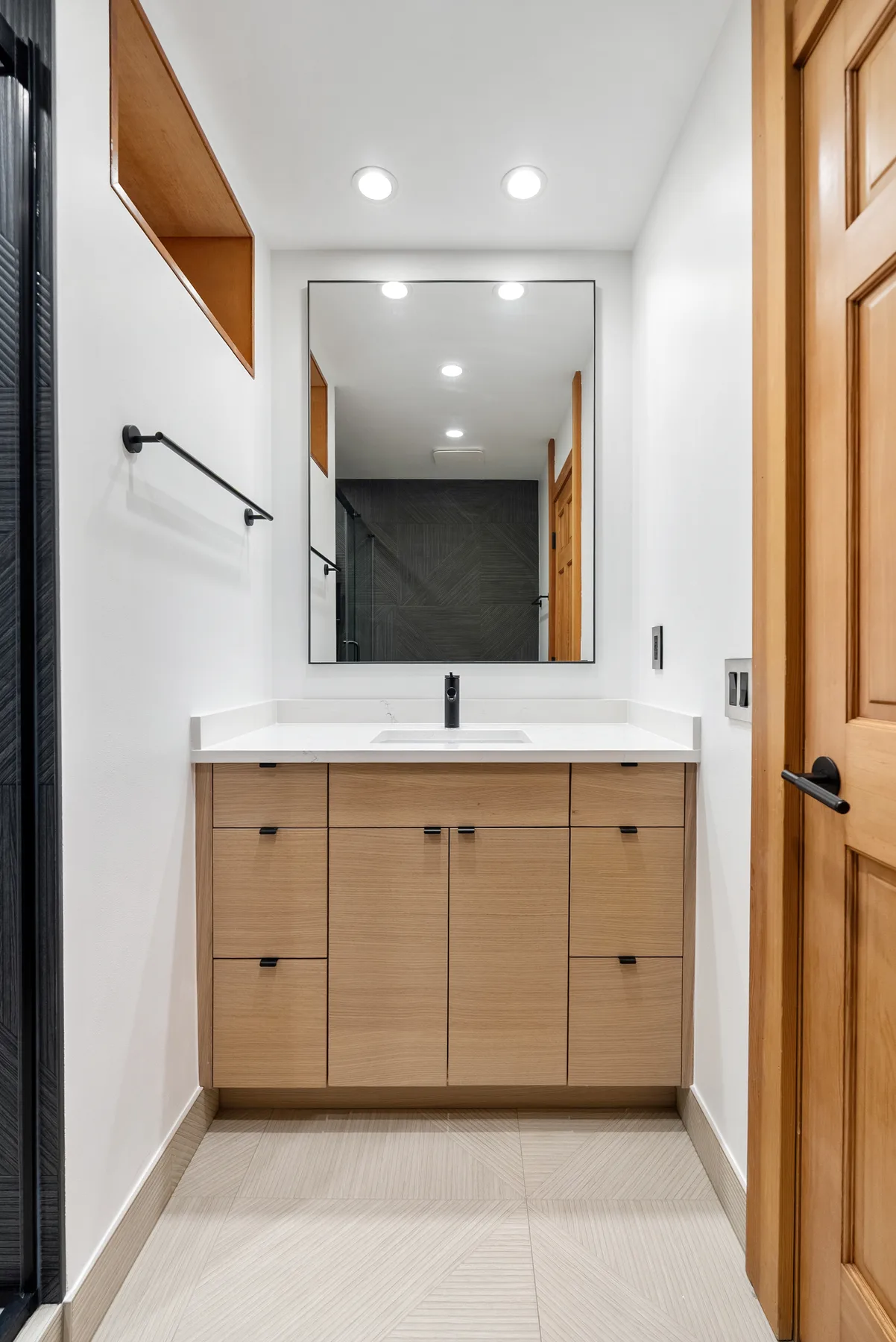 Oak vanity with white quartz and black mirror in the Redmond main bathroom