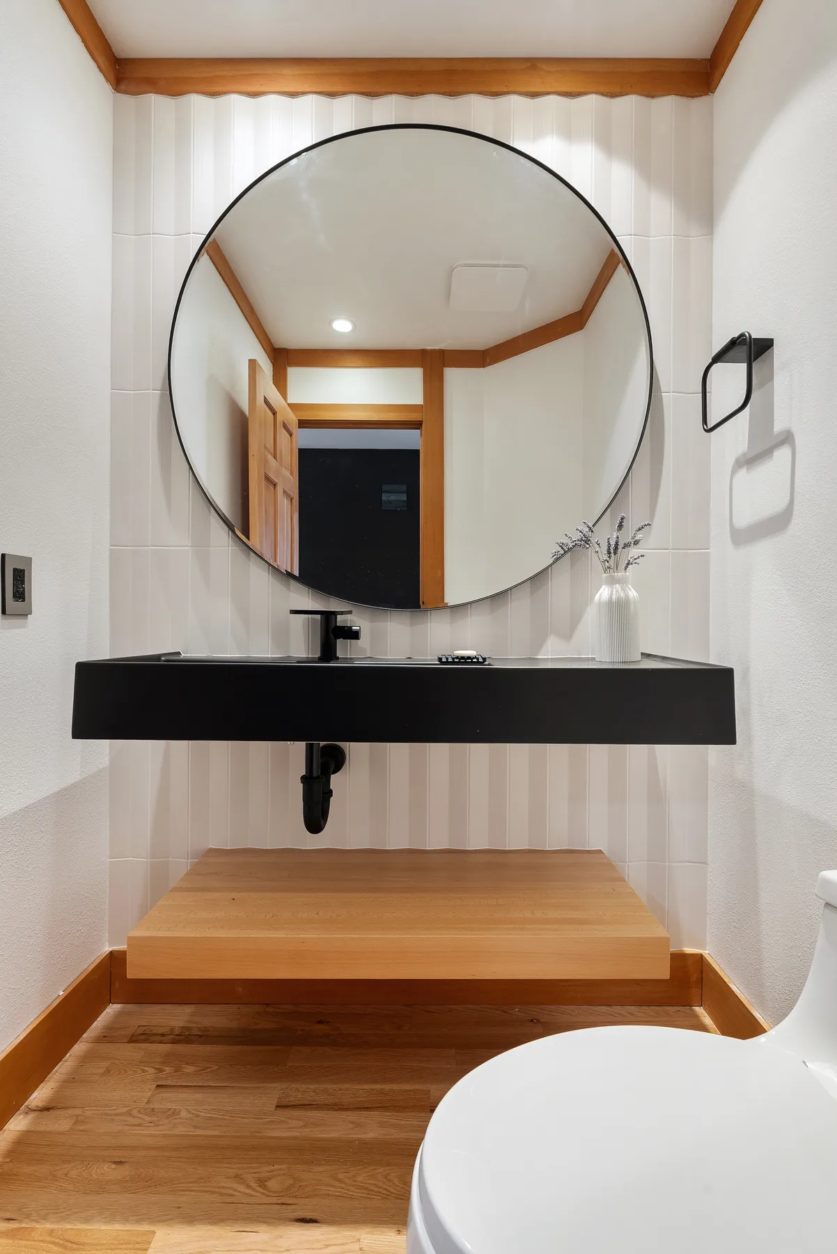 Floating black vanity and round black-framed mirror, Redmond powder room