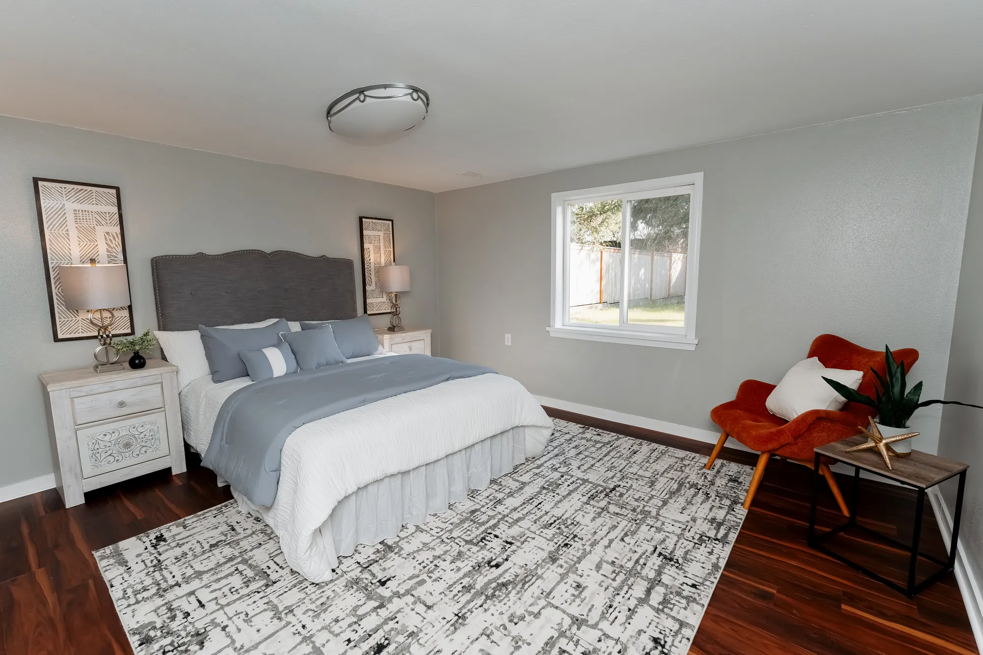 Second bedroom with accent chair after restoration