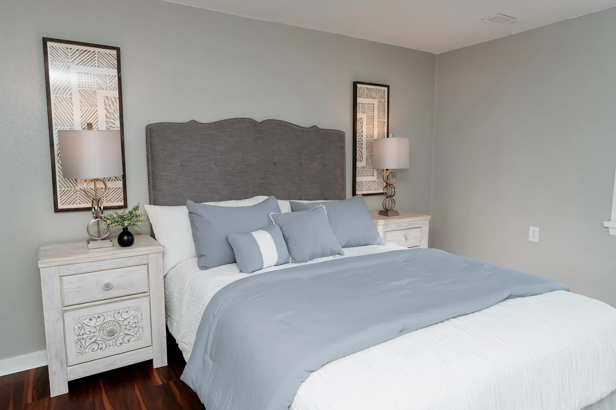 Guest bedroom with upholstered headboard after restoration
