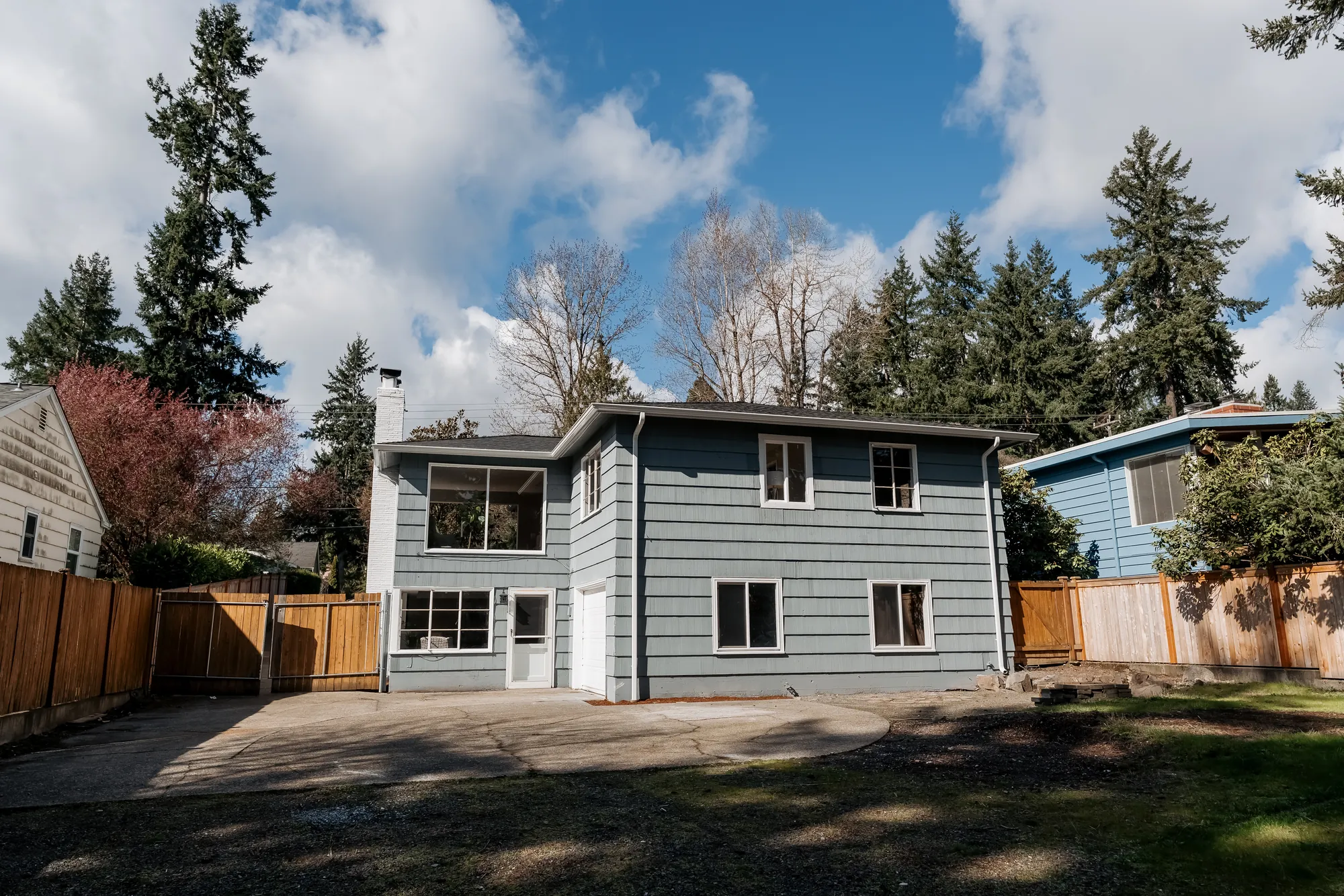 Rear exterior of the two-story restored home and yard