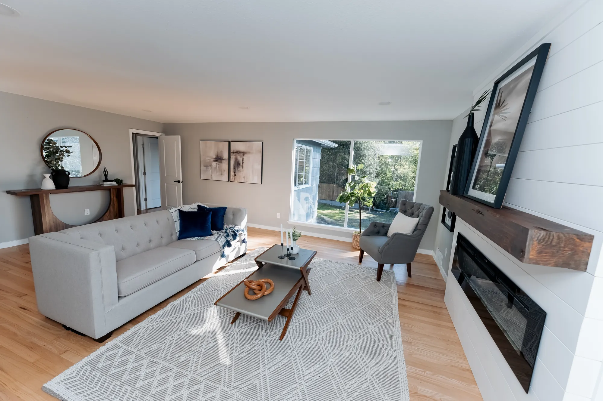 Staged main-floor living room with fireplace after restoration, Seattle
