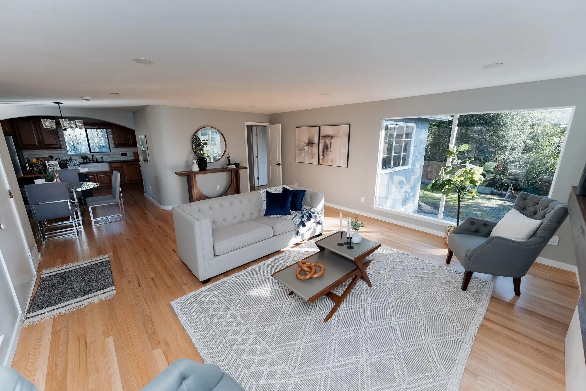 Open-plan living and dining area with hardwood floors after restoration, Seattle
